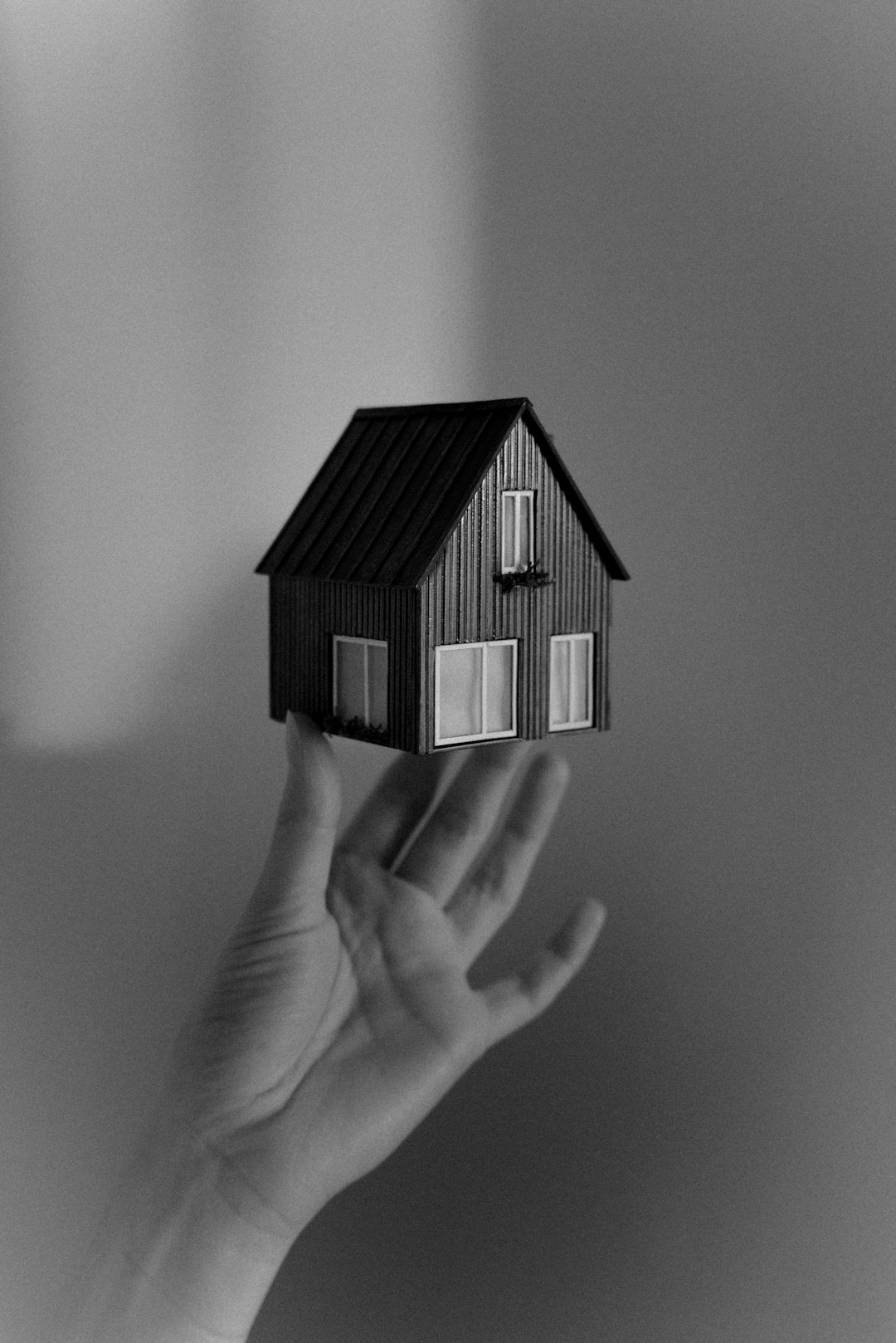 a-person-holding-a-small-house-in-their-hand-qdpaish2ngk